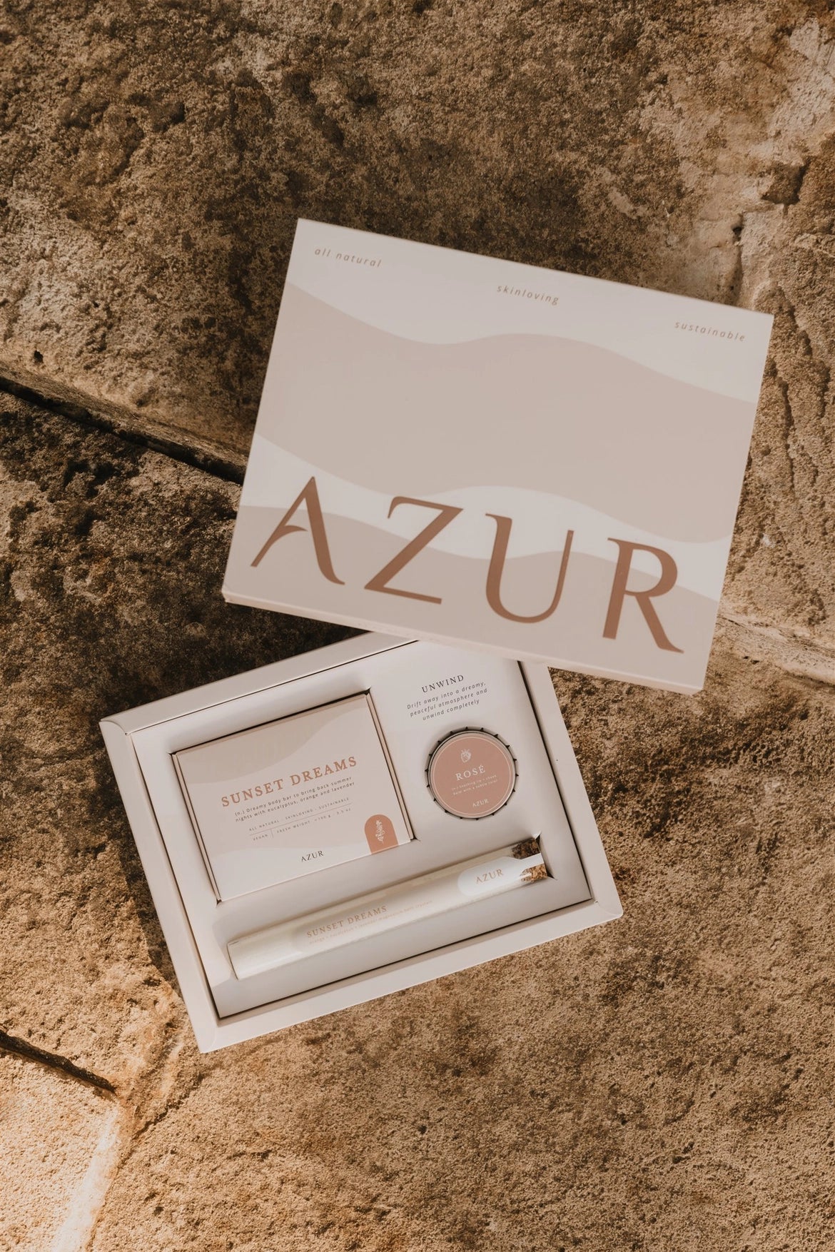 Unwind bath gift set with 'AZUR' branding on a stone surface with bath salts and natural body soap