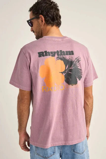 the back of a man wearing a printed rhythm tropic radio t-shirt