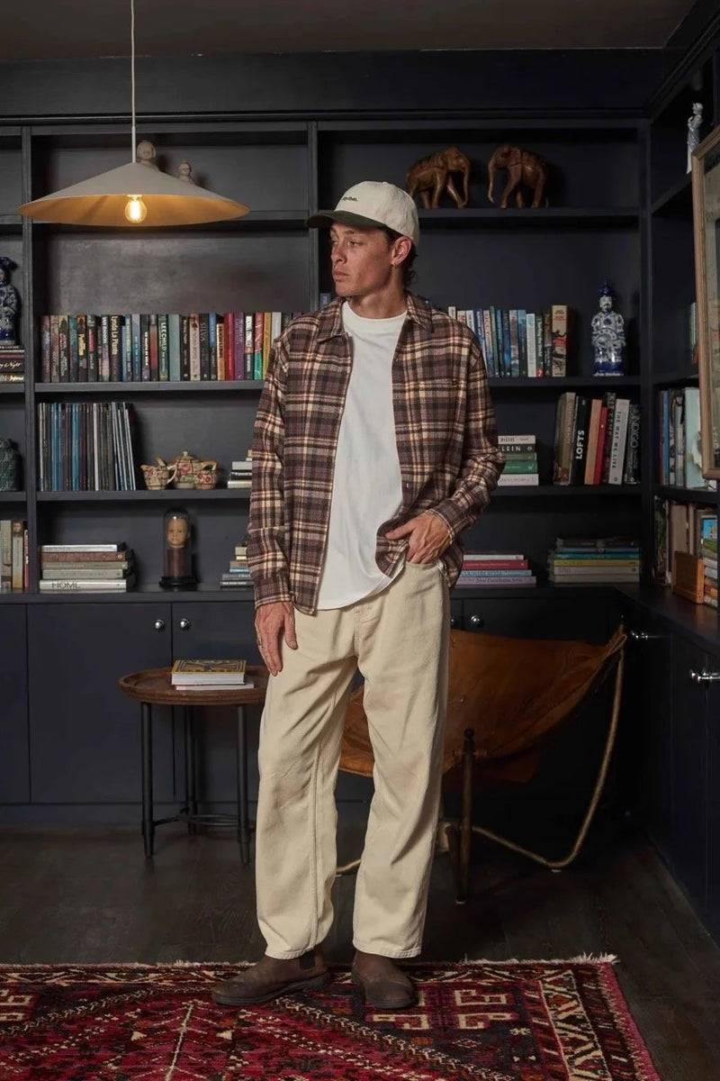 Man standing in a room with bookshelves and a rug