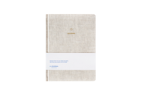 Beige linen hard cover journal on a white background