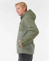 Person wearing a green rip curl anti series fleece jacket on a white background