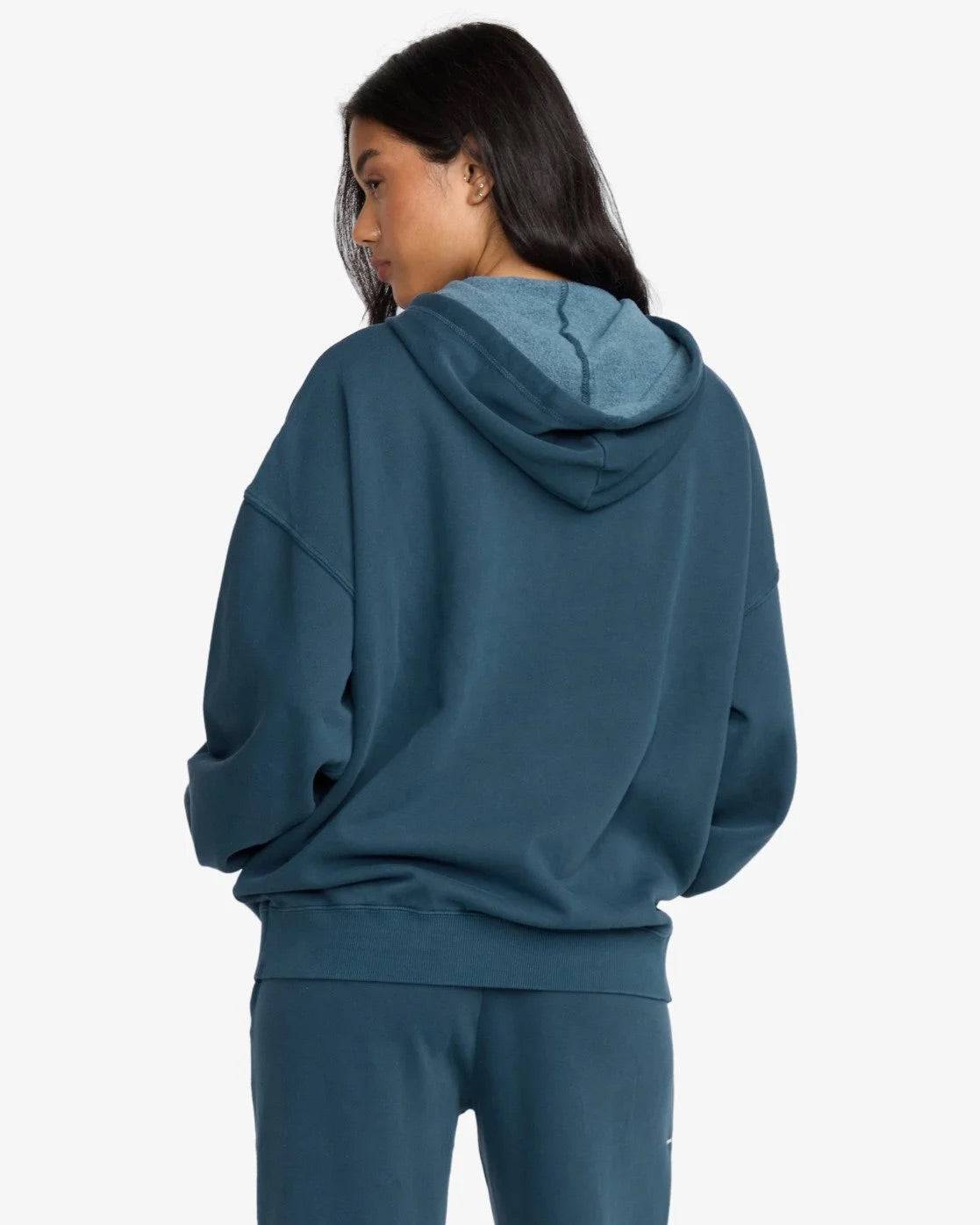 Person wearing a teal billabong hoodie and pants on a white background