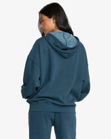 Person wearing a teal billabong hoodie and pants on a white background
