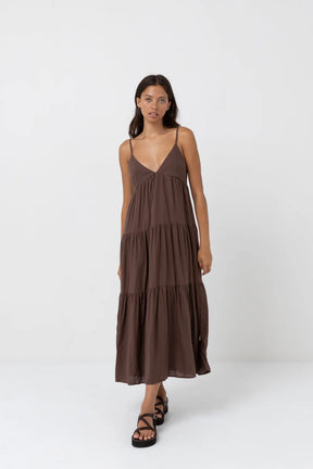 Woman wearing a rhythm chocolate tiered maxi dress on a white background