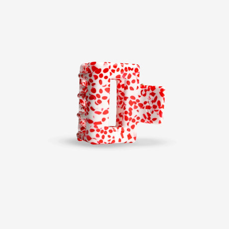 Red and white polka dot letter hair clip on a light gray background