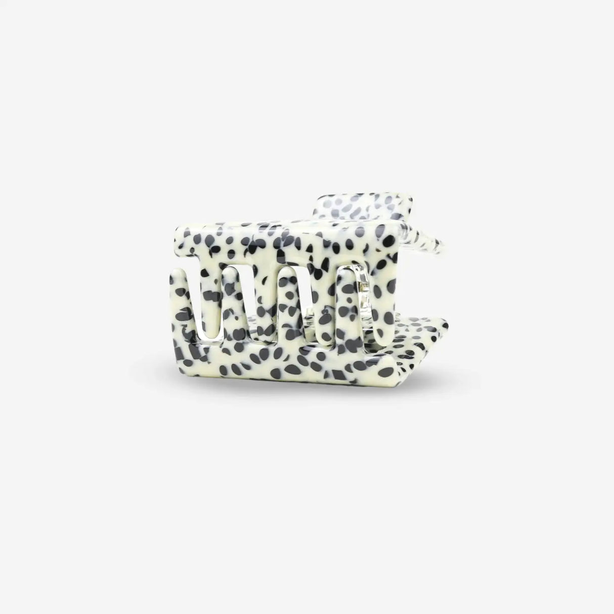 White hair clip with black polka dot pattern on a white background