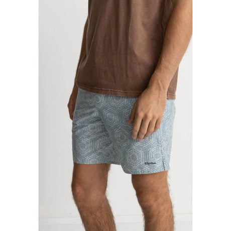 a man wearing a brown t-shirt and rhythm gleam trunks