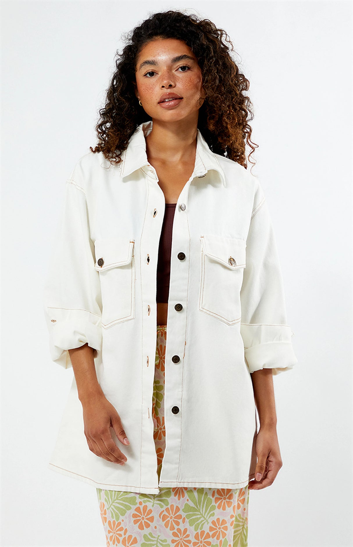 Woman wearing a rhythm camilla oversized white denim jacket on a white background