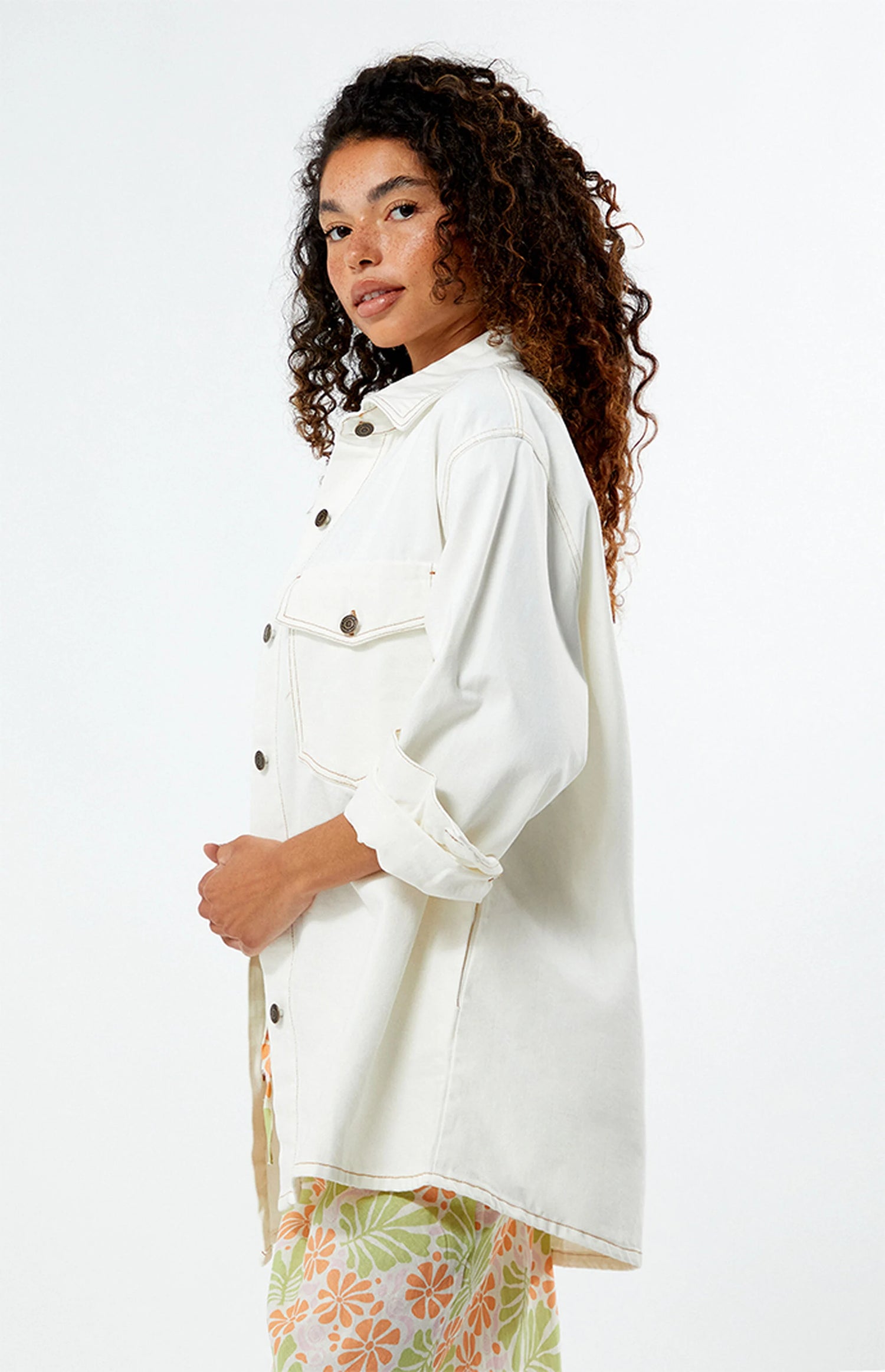Woman wearing a rhythm camilla oversized white jacket on a plain background