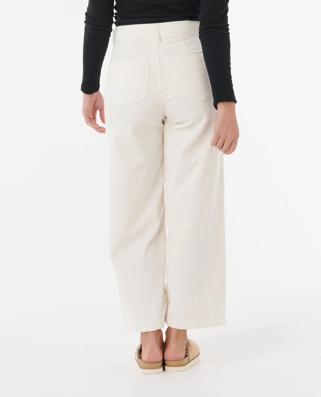 Person wearing white pants and a black top on a white background