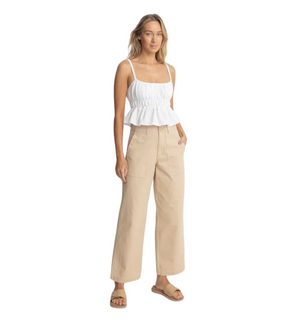 Woman wearing a white top and rhythm fatigue pants on a white background