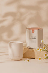 Ceramic candle with 'AZUR' branding and a box labeled 'Sunset Dreams' on a beige background.