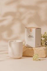 White ceramic candle labeled 'AZUR' with a 'Wild Flower' box on a beige background