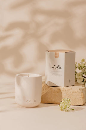 White ceramic candle labeled 'AZUR' with a 'Wild Flower' box on a beige background